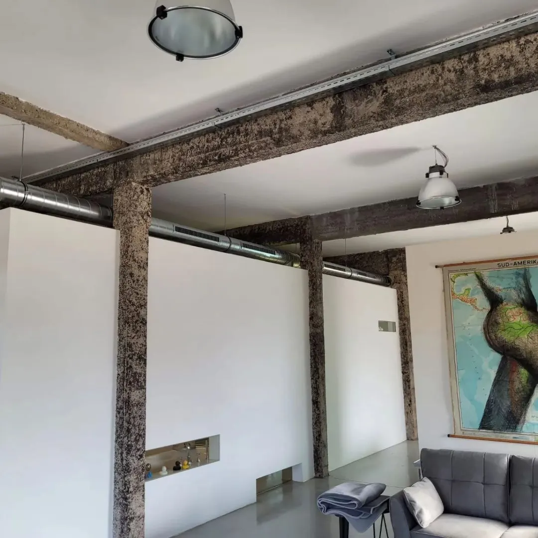 Strak weggewerkt ventilatiekanaal langs de betonstructuur van een loft